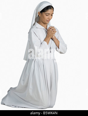 Nahaufnahme einer Nonne kniend im Gebet position Stockfoto
