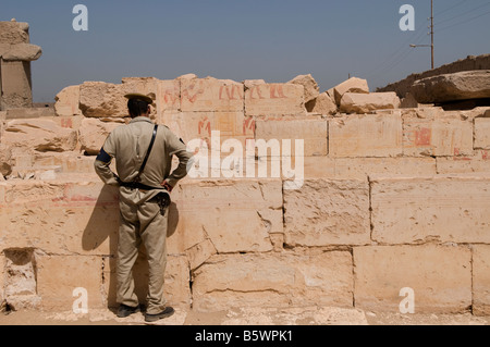 Ein ägyptischer Polizist Blick auf Fragmente von Hieroglyphen im Tempel von Ramses II. in Abydos eine der ältesten Städte des Alten Ägypten Stockfoto