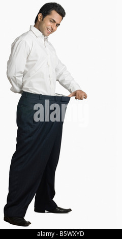 Porträt eines jungen Mannes erstreckt sich seine Hose und lächelnd Stockfoto