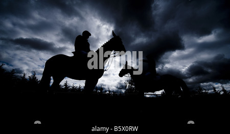 Reiter auf ihren Pferden sind gegen ein bewölkter Himmel während der Toledo CSI Pferd springen Meisterschaft in Zentralspanien Silhouette. Stockfoto