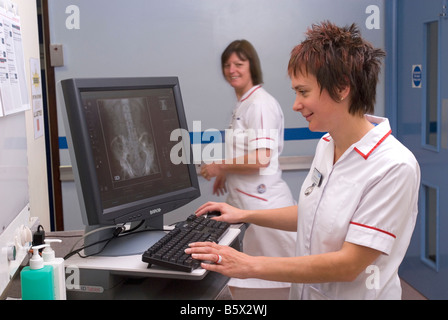 Eine MTRA bespricht ein Patienten-Diagramm mit einem Arzt in einem Krankenhaus Stockfoto