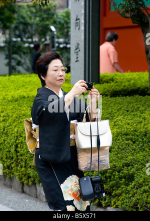 Japanerin mit dem Fotografieren in den Gärten der Sensoji-Tempel in Asakusa, Tokio, Japan. Stockfoto