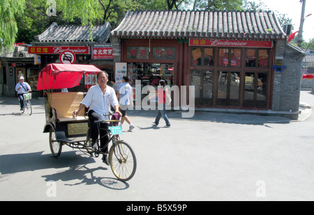 Ein Mann reitet eine Rikscha in einem Hutong auf den Straßen von Peking China Asien Stockfoto