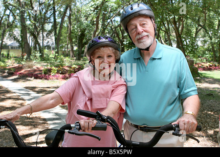 Ein attraktives senior paar Radfahren zusammen tragen Helme Stockfoto