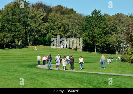 Gruppen von Menschen zu Fuß durch den üppig grünen Park auf warmen, sonnigen Tag im Newport Rhode Island USA Stockfoto