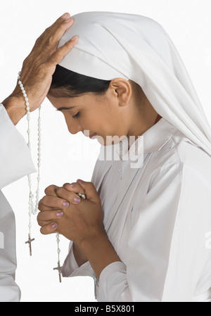 Nonne mit einem Priester ihre Sünden bekennen Stockfoto