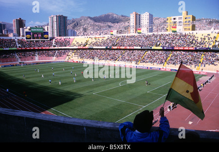 Junger männlicher Fan, der die bolivianische Nationalflagge während eines internationalen Fußballspiels im Olympiastadion Hernando Siles, La Paz, Bolivien, hält Stockfoto