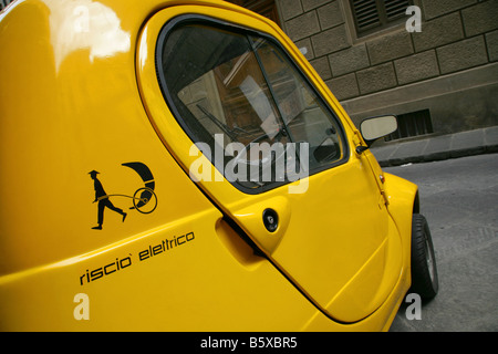 Kleine gelbe ein-Personen-Pasquali Riscio Elektroauto geparkt in Seitenstraße, Florenz, Italien. Stockfoto