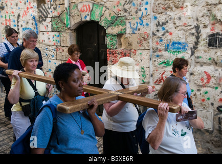 Israel Jerusalem alte Stadt Via Dolorosa 4 Frauen Pilger tragen ein hölzernes Kreuz entlang der Via dolorosa Stockfoto