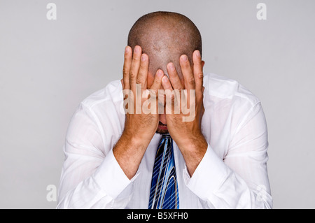 Deprimiert aus Arbeit Geschäftsmann mit Händen in Verzweiflung konfrontiert. Stockfoto