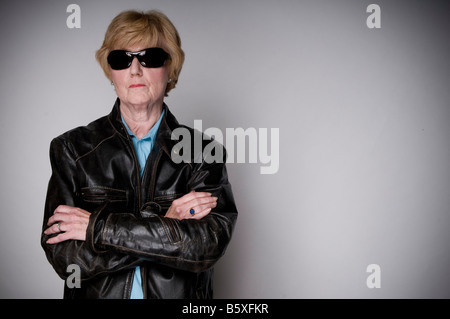 Ältere Frau mit Sonnenbrille und eine schwarze Lederjacke. Stockfoto