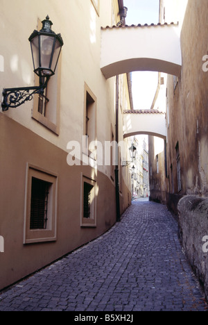 Lampe und Bögen über einen gepflasterten Fußgängerweg in den ruhigen Straßen der Altstadt unterhalb der Prager Burg, Tschechische Republik Stockfoto