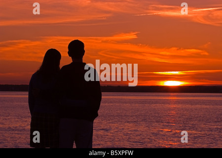 Silhouette des jungen Paares stehen am Strand bei Sonnenuntergang Stockfoto