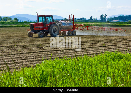 Ein Traktor zieht eine Spray-Rig sprüht einen frisch gepflanzten Kartoffelacker zur Unkrautbekämpfung im nordwestlichen Washington Stockfoto