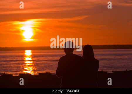 Silhouette des jungen Paares stehen am Strand bei Sonnenuntergang Stockfoto