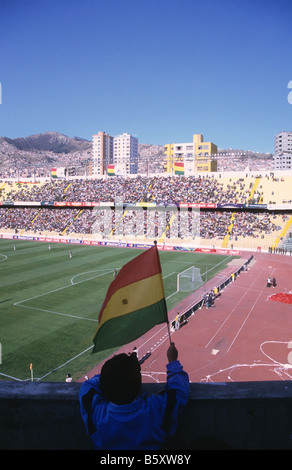 Junger männlicher Fan, der die bolivianische Nationalflagge während eines internationalen Fußballspiels im Olympiastadion Hernando Siles, La Paz, Bolivien, hält Stockfoto