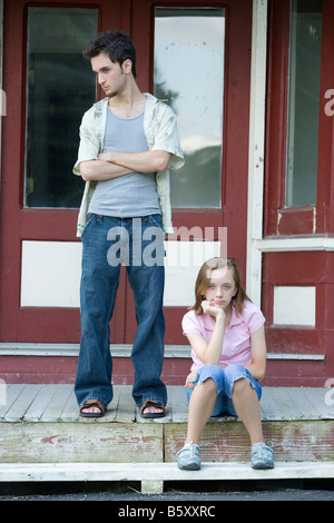 Ein paar Jugendliche sitzen Sie draußen auf der Stufe des Landes General Store. Stockfoto