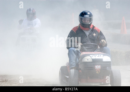 Zwei Rasenmäher-Fahrer in einem Rennen auf einem Jahrmarkt. Stockfoto