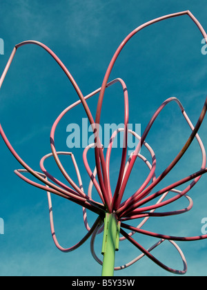 niedrigen Winkel Blick auf ein paar Stück Metall Skulptur, die Blumen in den verschiedenen Stadien des Blühens gegen blauen Himmel Stockfoto