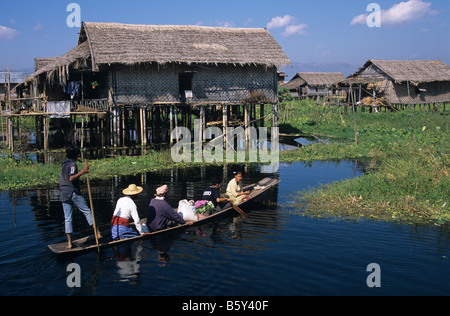 Eine burmesische Familie kehrt mit dem Kanu in ihrem Stelzenhaus am Inle-See, Burma bzw. Myanmar Stockfoto