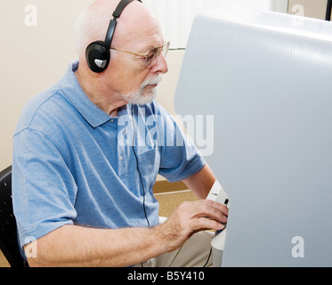 Senior Woman Kopfhörer und Abstimmung über eines der neuesten Touch Bildschirm Maschinen in Florida und anderen Staaten Stockfoto
