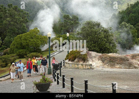 Touristen in das Dorf Furnas, São Miguel, Azoren, Portugal. Dämpfe aus heißen Quellen im Hintergrund Stockfoto