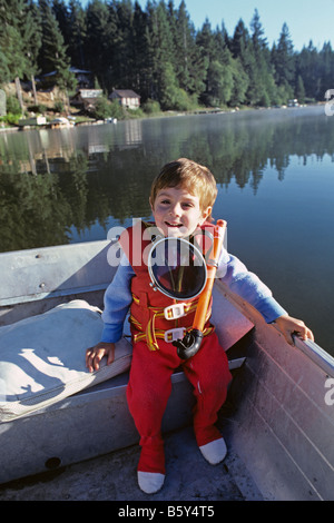 Kleiner Junge in einem Ruderboot in den frühen Morgenstunden mit Scuba gear um Hals auf See Mason auf der Olympic Halbinsel Washingotn Zustand