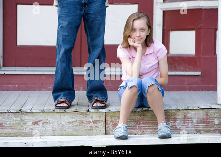 Ein paar Jugendliche sitzen Sie draußen auf der Stufe des Landes General Store. Stockfoto