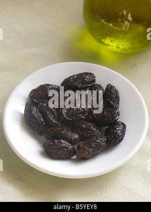Kultiges griechisches Essen schwarze Oliven und kalt gepresstes Olivenöl aus Kreta Stockfoto