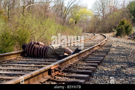 Ein Mann auf die Eisenbahn verfolgt nicht genau das klügste, was zu tun Stockfoto