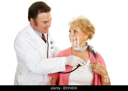 Arzt mit einem Stethoskop um zu hören ein senior Frau s Herz schlagen isoliert auf weiß Stockfoto