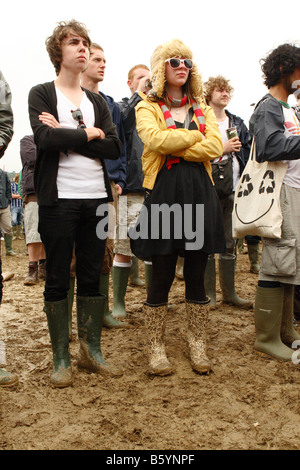 Fans tragen Gummistiefel im Schlamm beobachten live-Musik auf dem Glastonbury Rock Festival Juni 2008 Stockfoto