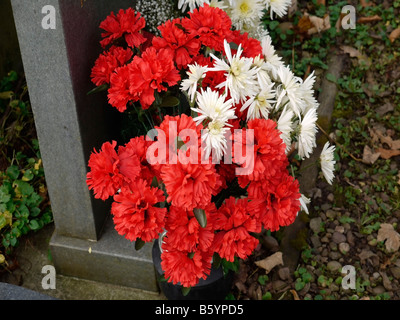 Blumen auf ein Grab auf einem Friedhof Stockfoto