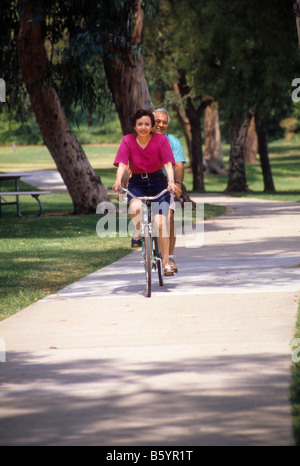 Hispanische paar Fahrrad Tandem im Park. Stockfoto