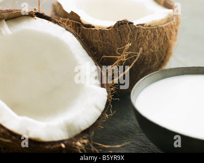 Schüssel mit Kokosmilch mit einer frischen Kokosnuss Split Stockfoto