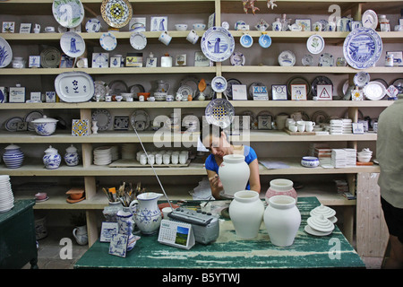 Frau malt bei Ceramica Vieira Töpferei in Lagoa, Azoren, Portugal. Die rötliche Farbe wird in den brennenden Ofen blau. Stockfoto