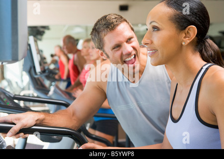 Personaltrainer, die Förderung der Frau mit Laufband im Fitnessstudio Stockfoto