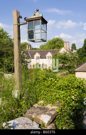 Eine rustikale Steinhaus in der Cotswold Dorf von Swinbrook, Oxfordshire - gesehen aus einer Ecke des dem Kirchhof Stockfoto