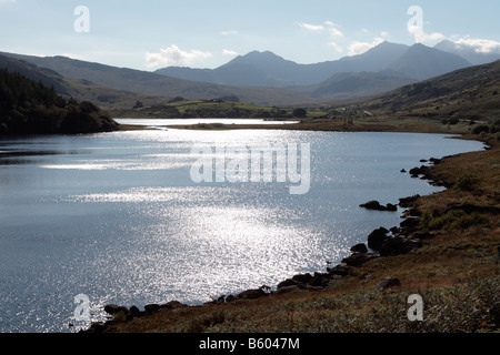 Blick von Capel Curig Richtung Snowdon Sonnenlicht glitzerte auf Llnnau Mymbyr See im Vordergrund Stockfoto