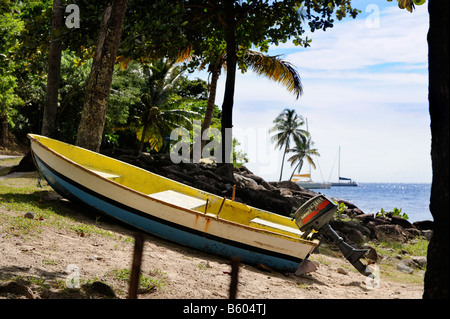 EIN KLEINES FISCHERBOOT IN DEN FARBEN DER FLAGGE ST LUCIAN VON VERBOTENEN STRAND IM JALOUSIE PLANTATION RESORT ST. LUCIA Stockfoto