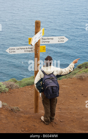 Weibliche Wanderer lesen Fußweg unterzeichnet am Küstenweg in das Anaga-Gebirge, der Norden von Teneriffa Stockfoto