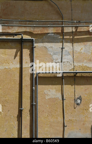Strom macht Verdrahtung Schaltung Rohre Rohre auf Seite des Eigentums Wand in Sonne Stockfoto