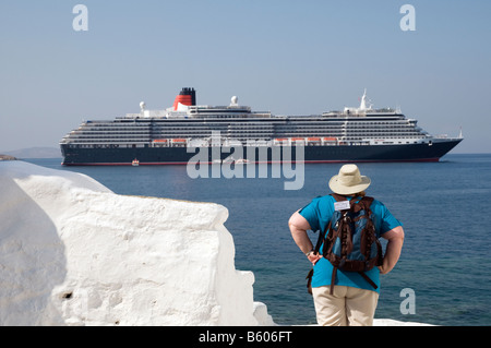 Amerikanische Touristen mit Königin Victoria Kreuzfahrtschiff im Hintergrund auf Mykonos, Griechenland Stockfoto