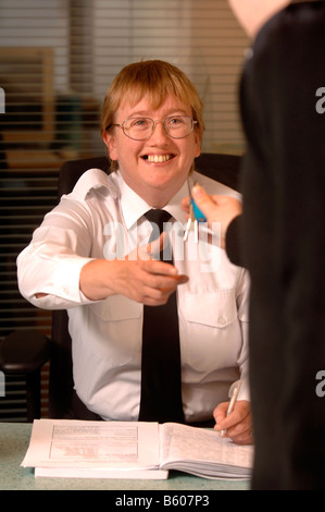 EIN WACHMANN AUF PATROUILLE PÄSSE-TASTEN, UM EINE FRONT DESK SECURITY OFFICER AT A BUSINESS RÄUMLICHKEITEN UK Stockfoto