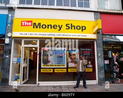 Mann auf einem Mobiltelefon außerhalb The Money Shop in Lewisham High Street London England. Stockfoto