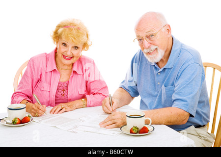 Älteres Paar ihre abwesender Stimmzettel für die bevorstehenden Wahlen isoliert auf weiß ausfüllen Stockfoto