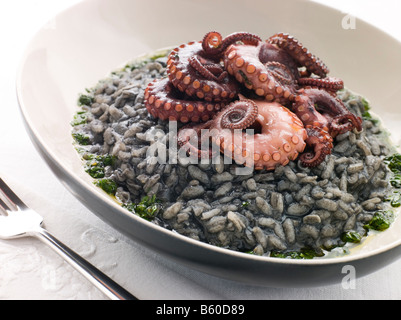 Risotto Nero mit gebratener Tintenfisch und Pesto-Dressing Stockfoto