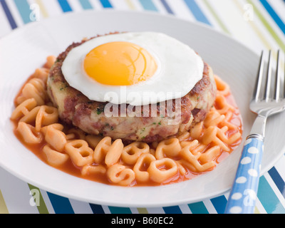 Corned Beef Hash Kuchen mit Alphabet Pasta und ein Spiegelei Stockfoto