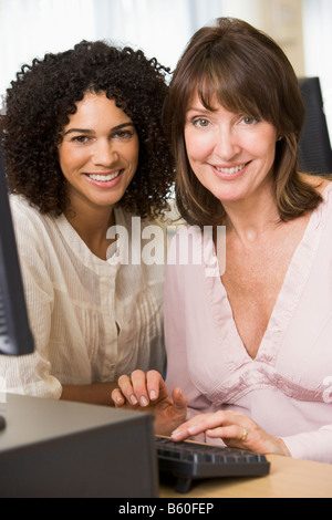 Zwei Frauen an einem Computer terminal eingeben (high-Key) Stockfoto