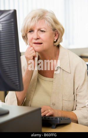Frau sitzt an einem Computer-terminal aufgeregt (high-Key) Stockfoto